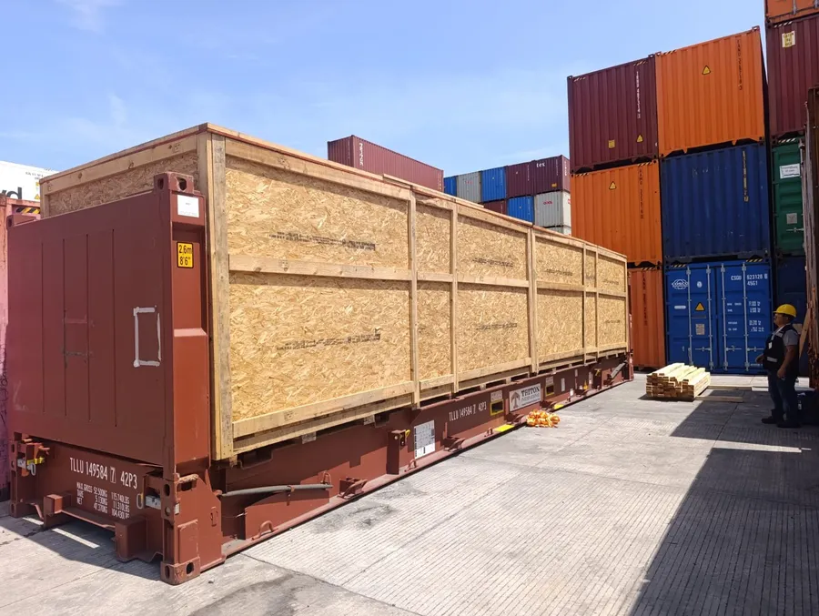 Huacal de exportación de maquinaria embarcado en flat-rack en puerto