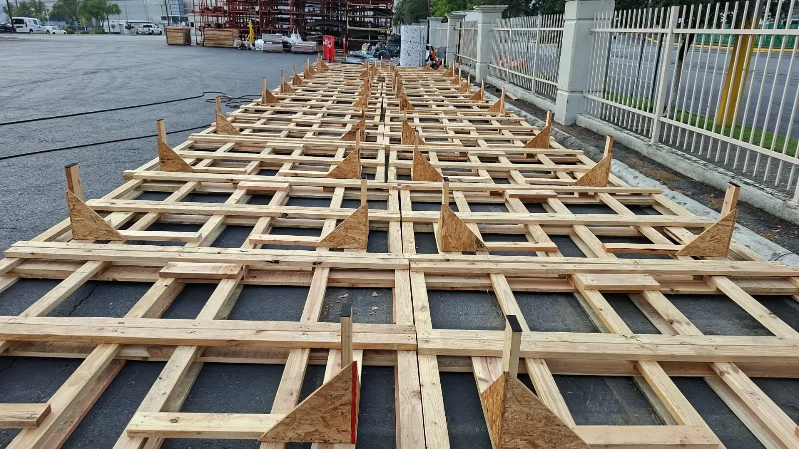 Bases de madera de medida especial fabricadas a plano, alineadas en patio de Hamer Empaques