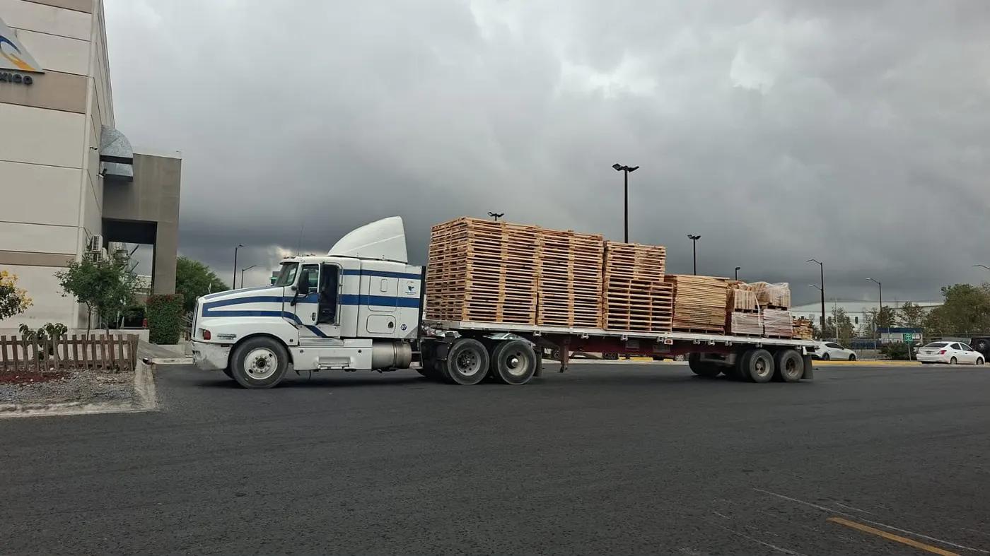 Plataforma cargada con tarimas de madera nuevas de Hamer Empaques lista para embarque